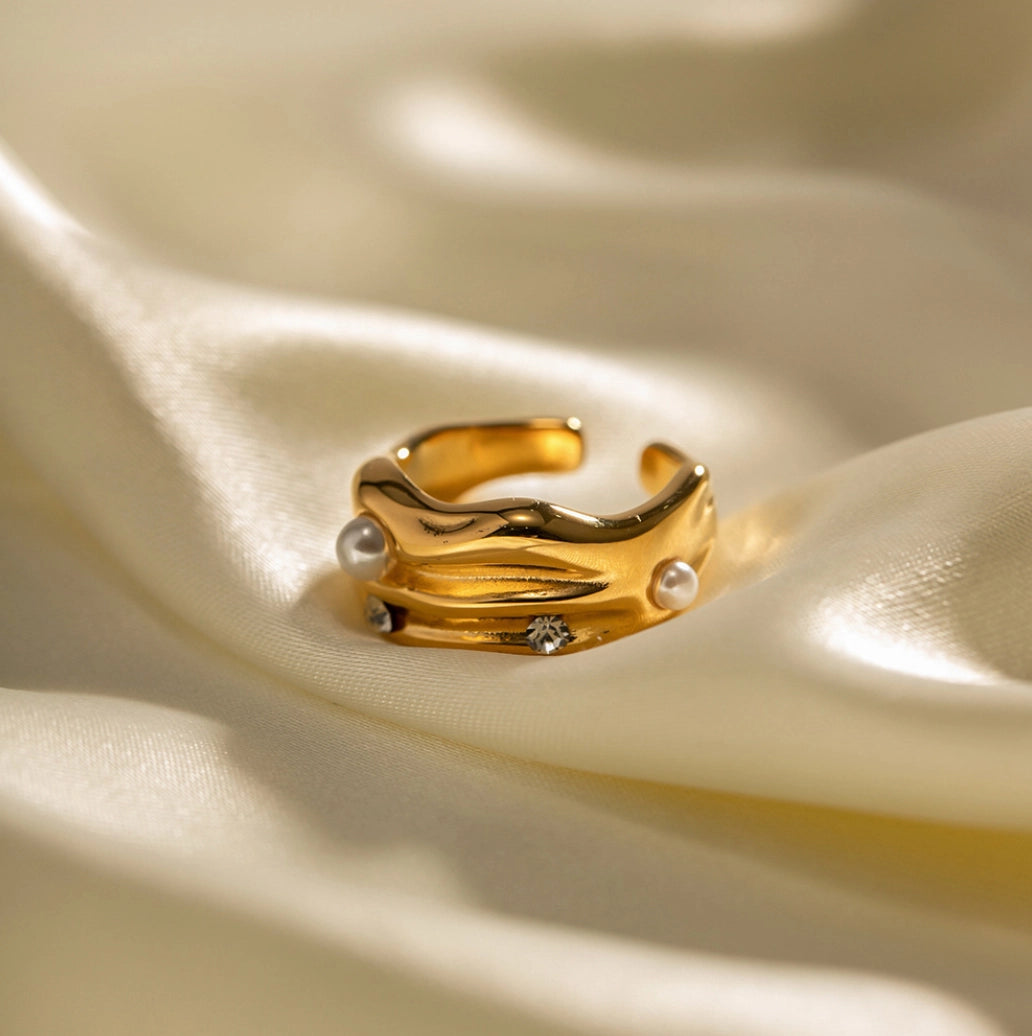 Gold ring with pearls on a beige fabric background