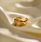 Gold ring with pearls on a beige fabric background