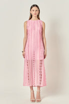 Woman wearing a pink lace dress on a white background