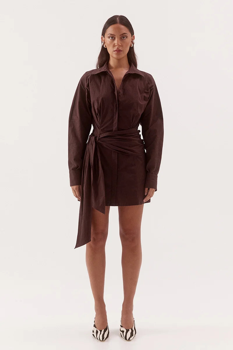 Woman wearing a brown shirt dress on a white background