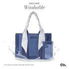 Blue handbag with floral accents and a phone case, labeled 'Machine Washable' on a white background.