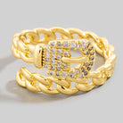 Gold chain ring with a diamond-encrusted belt buckle clasp on a light gray background