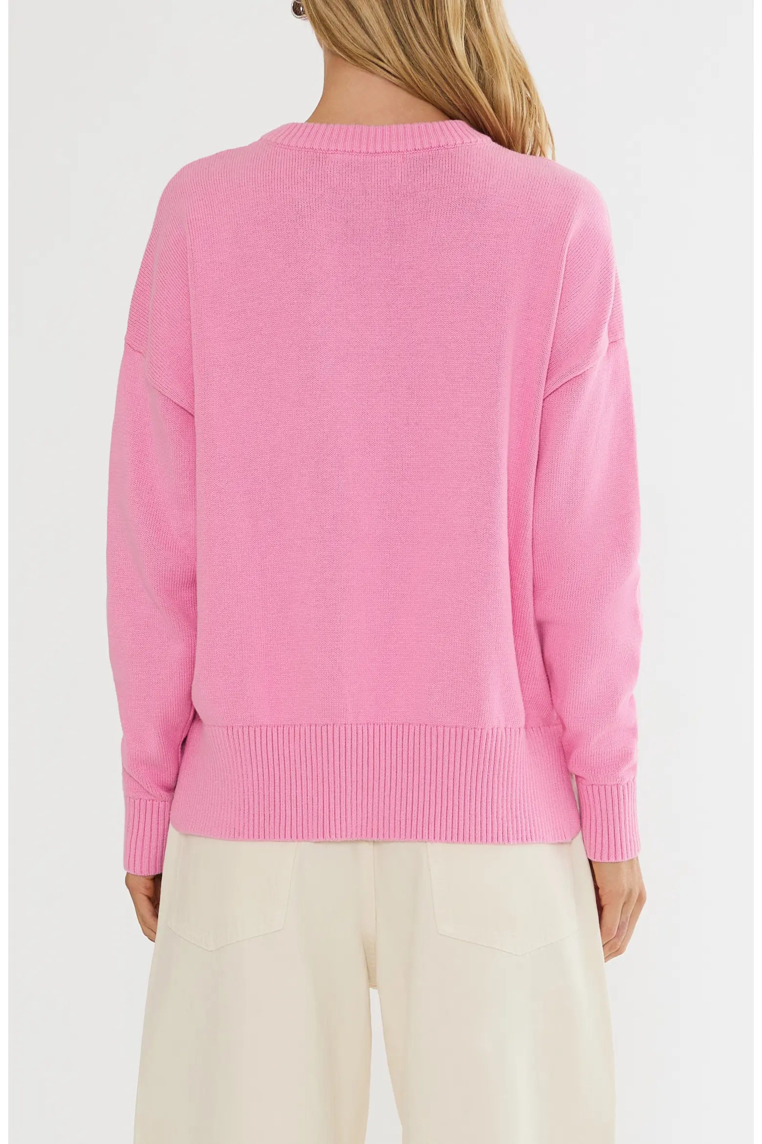 Pink sweater worn by a person on a white background