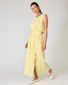 Woman wearing a yellow eyelet matching set against a white background