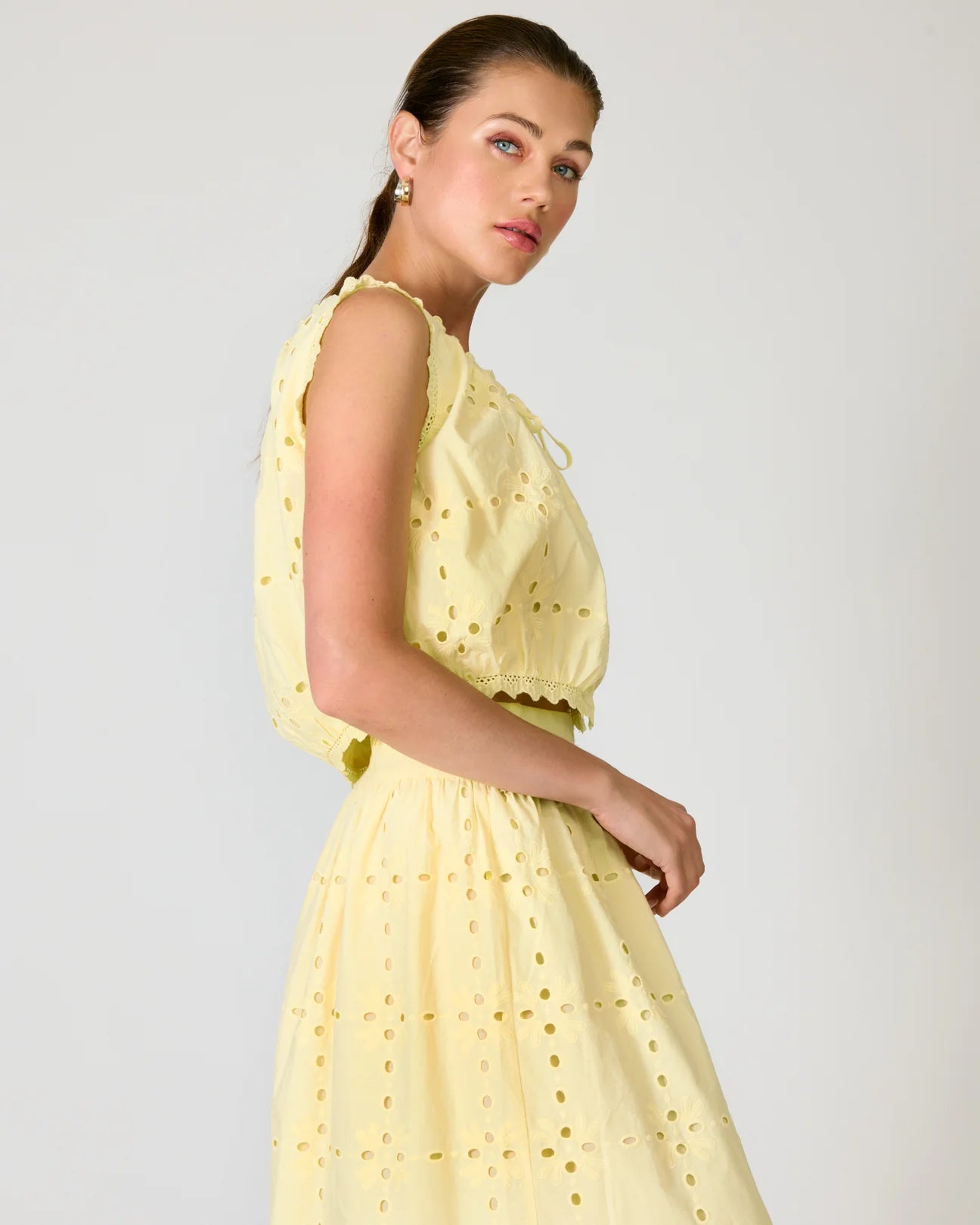 Woman wearing a yellow set with a white background