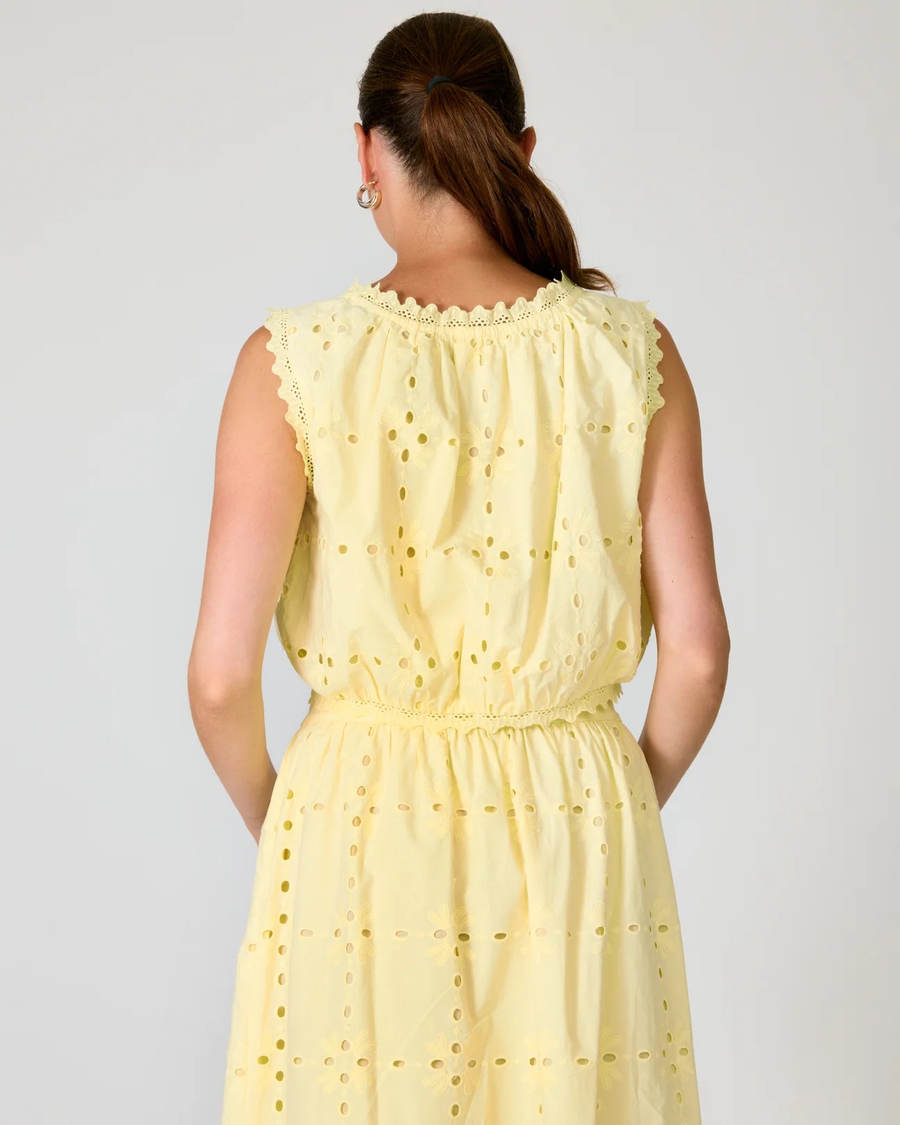 Woman wearing a yellow set with a white background