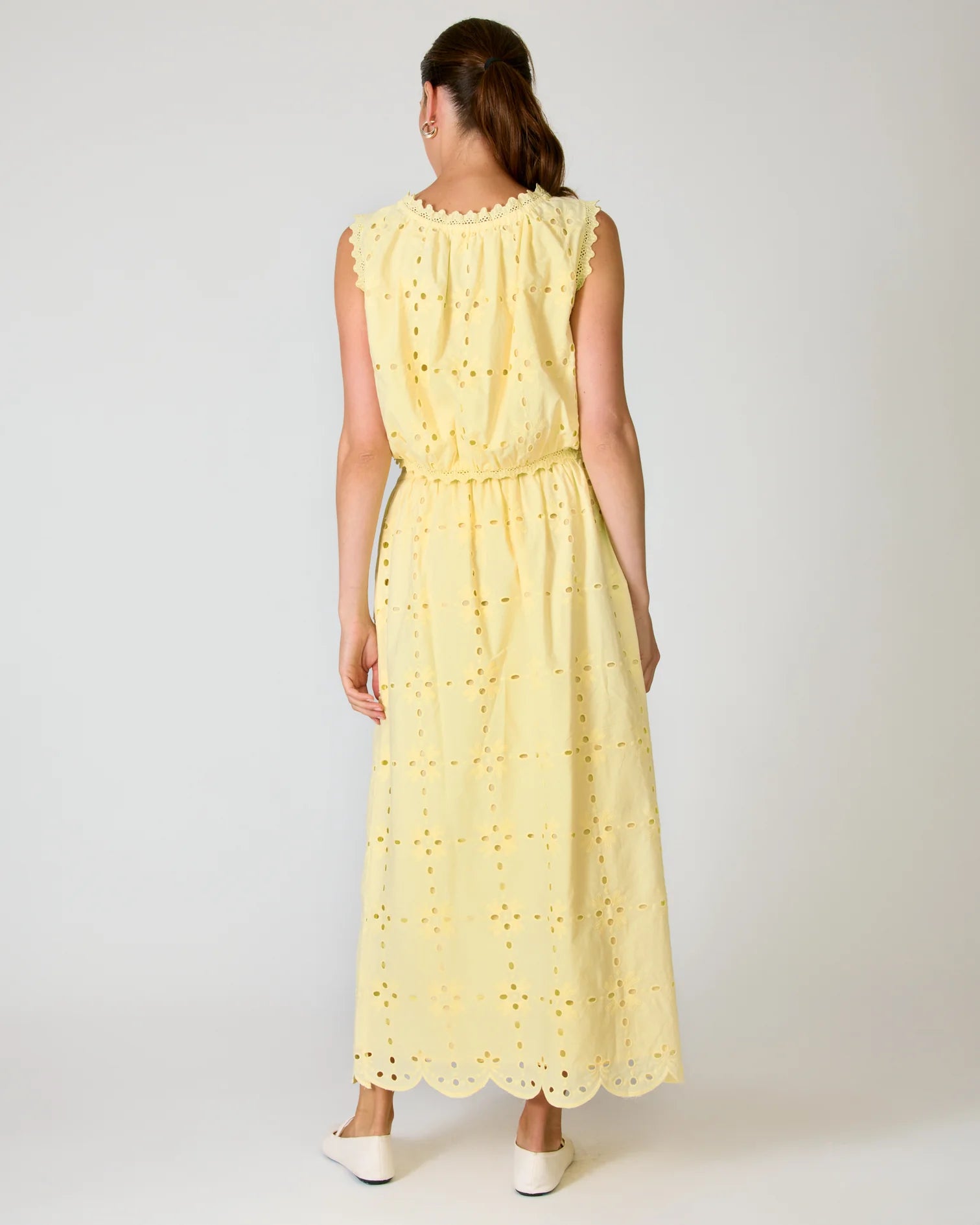 Woman wearing a yellow matching set with a white background