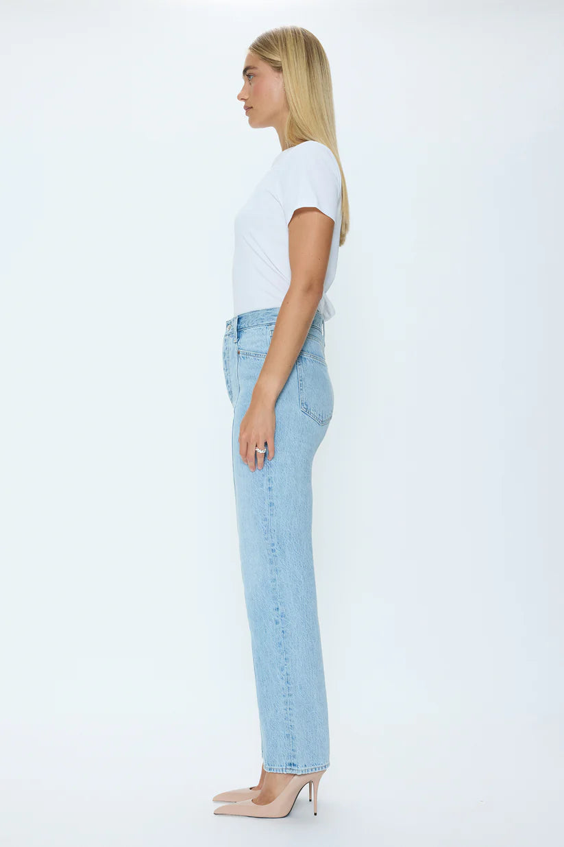 Woman wearing light blue jeans and a white t-shirt on a white background