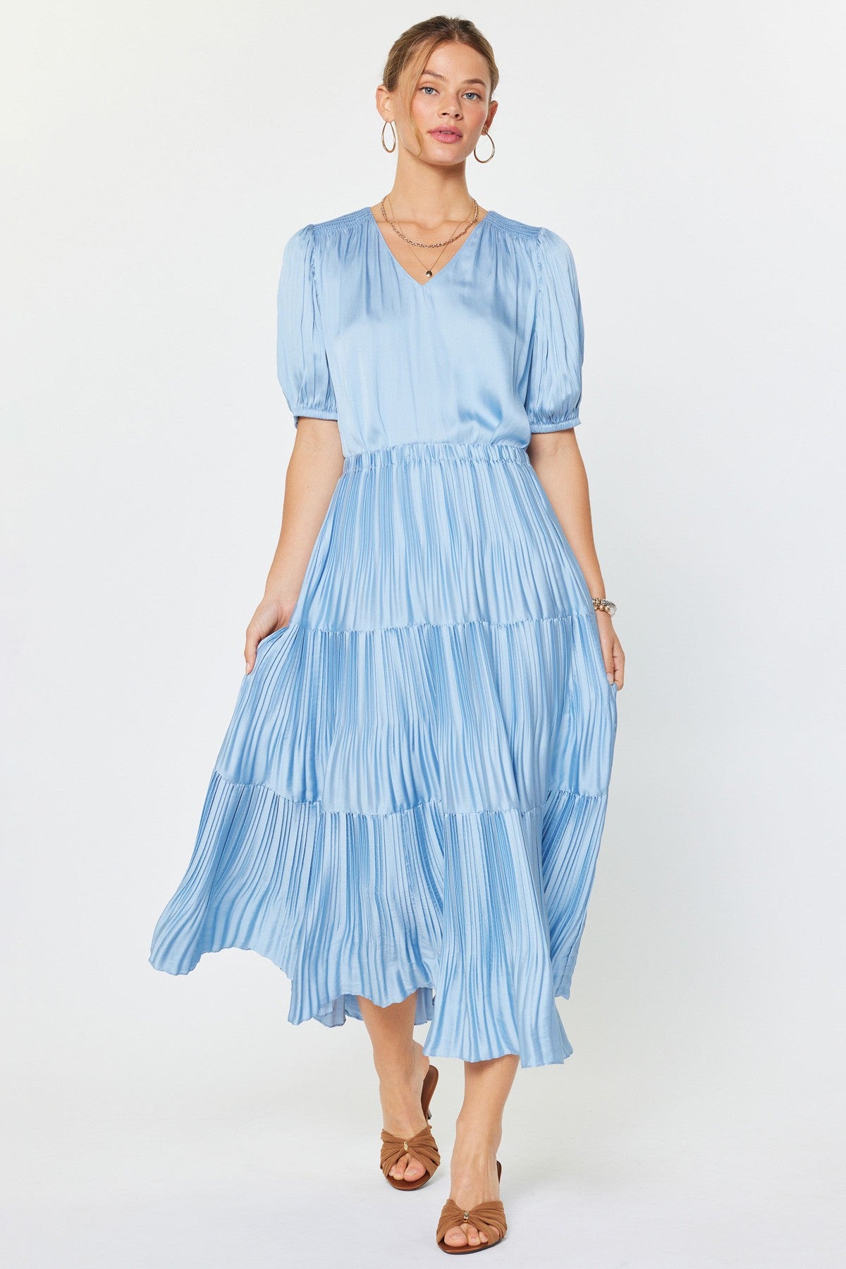 Woman wearing a light blue tiered dress on a white background