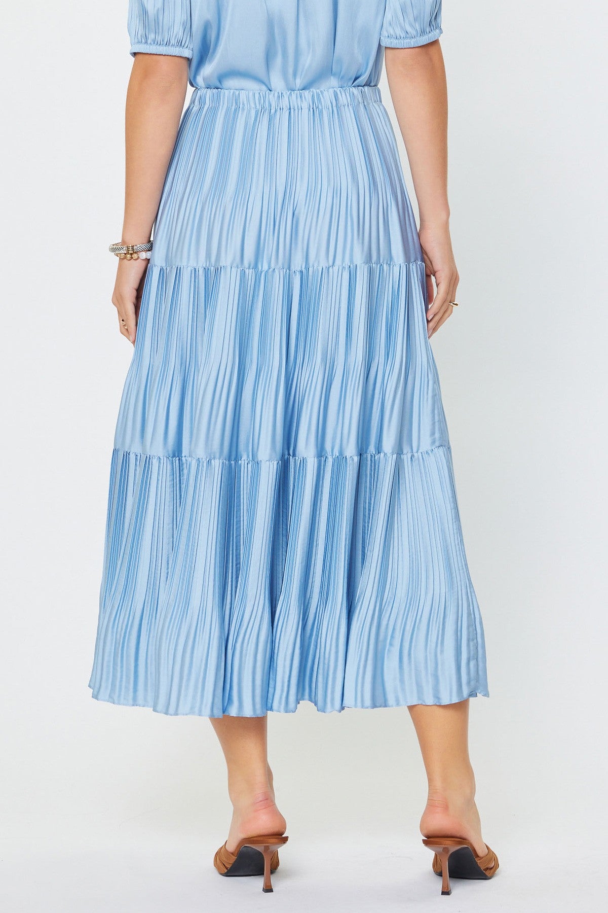 Woman wearing a blue tiered dress on a white background