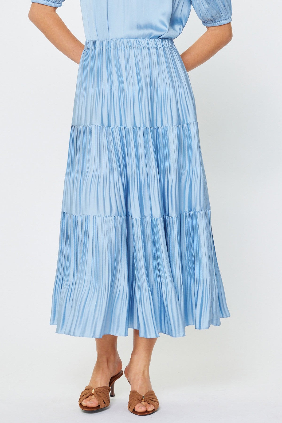 Woman wearing a blue tiered dress on a white background