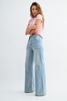 Woman wearing light blue jeans and a pink top on a white background