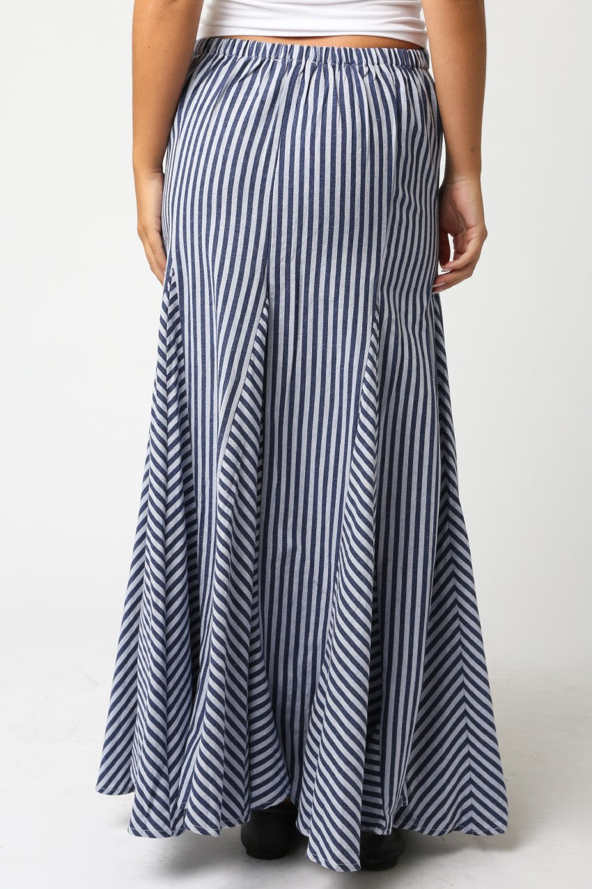 Person wearing a long blue and white striped skirt on a white background