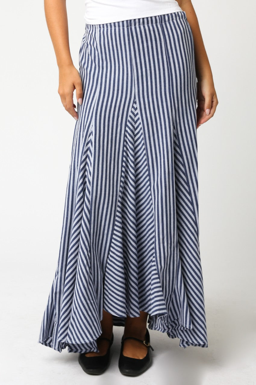Person wearing a long blue and white striped skirt on a white background