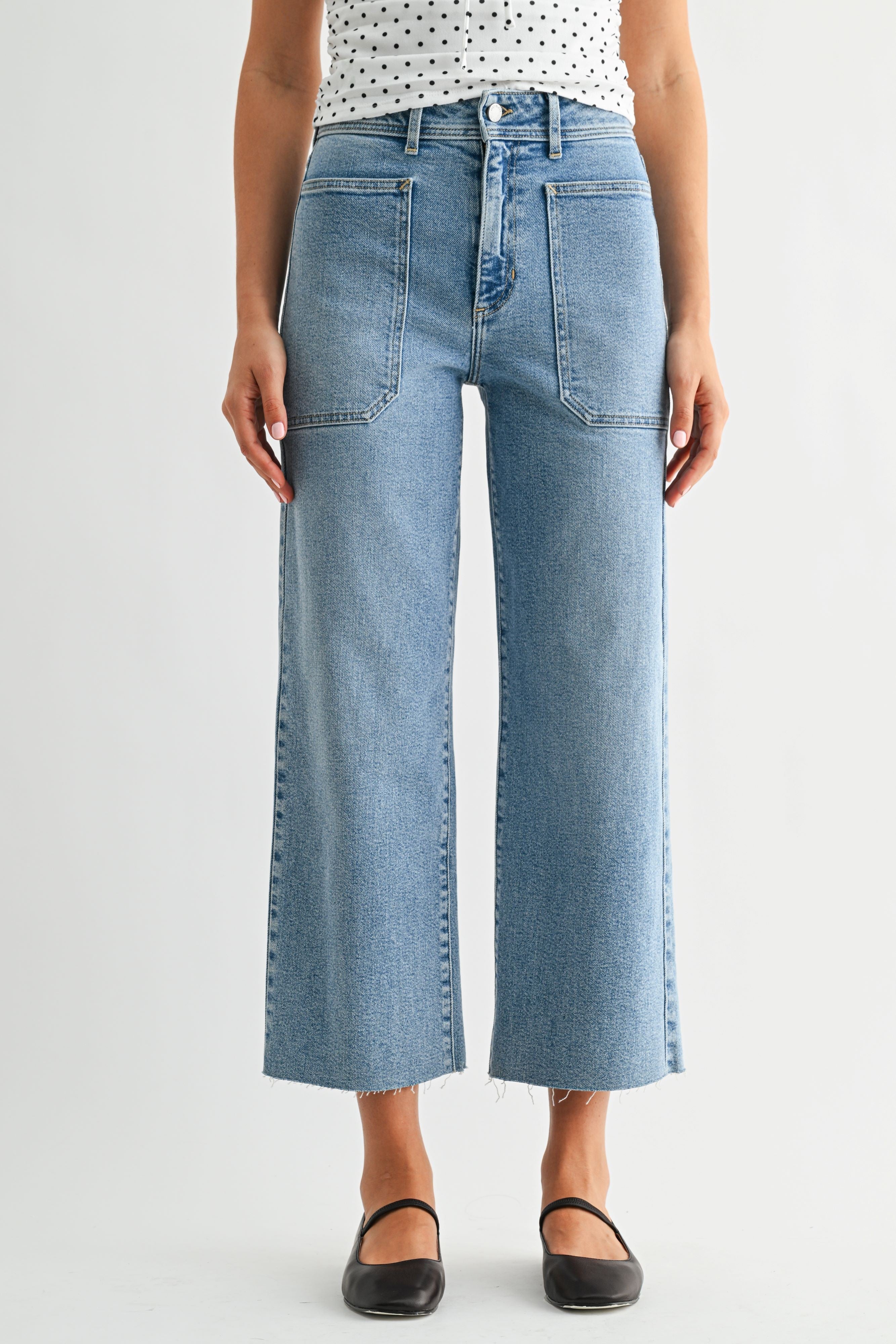 Person wearing light blue jeans on a white background