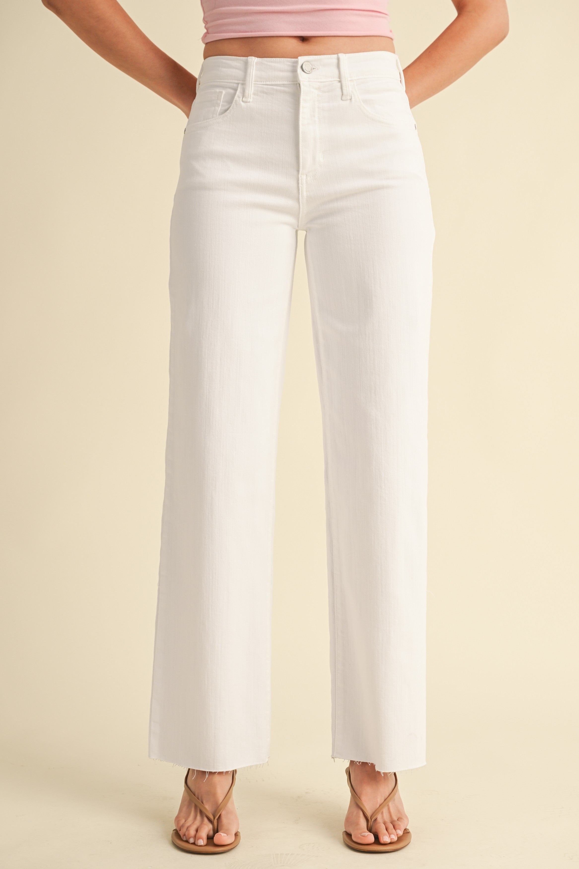 White wide-leg jeans worn by a person on a beige background