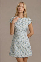 Woman wearing a floral dress against a beige background