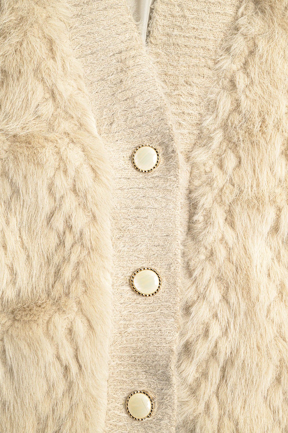 Close-up of a beige knitted cardigan with button details