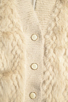 Close-up of a beige knitted cardigan with button details