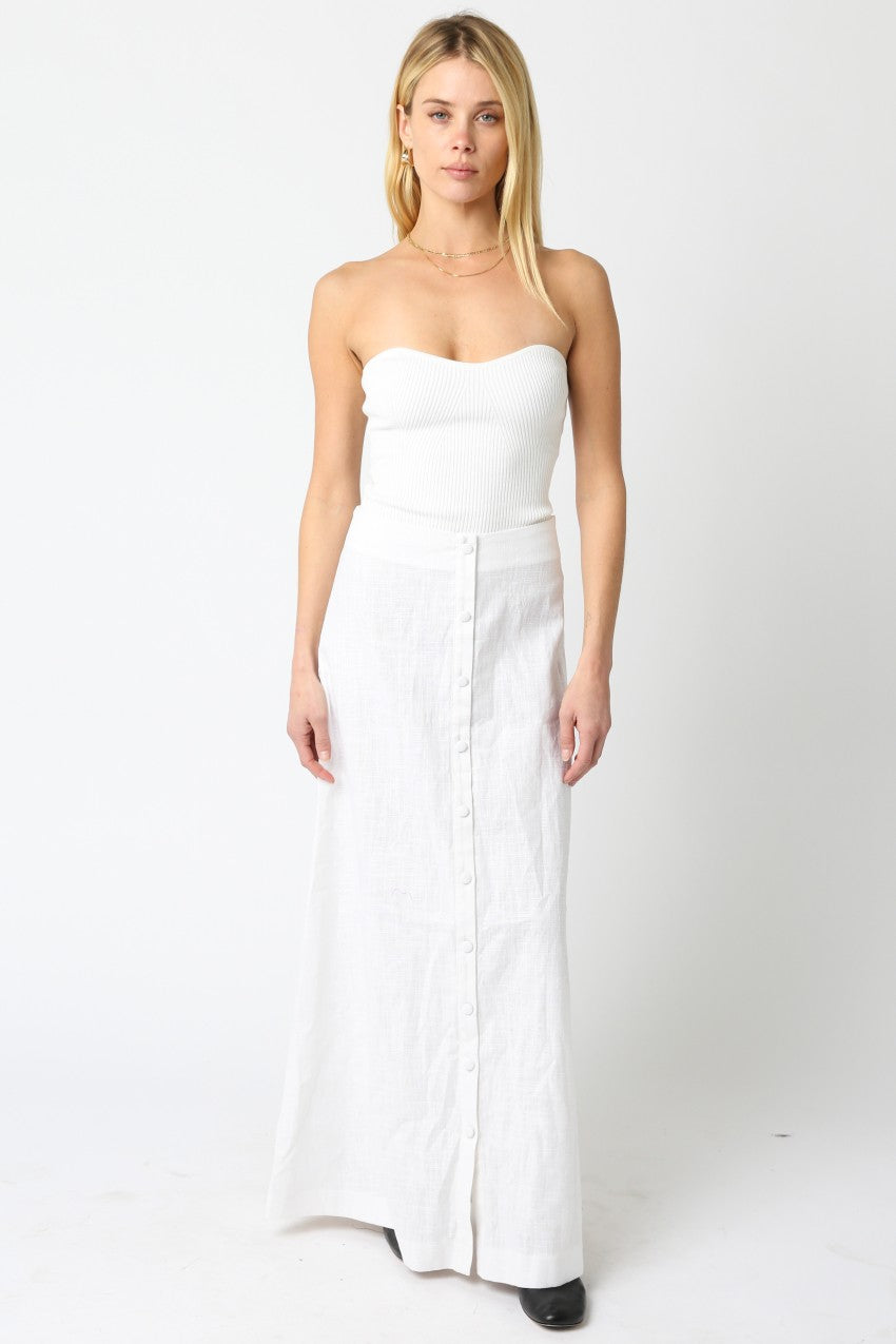 Woman wearing a strapless white dress on a white background