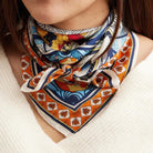Woman wearing a colorful patterned scarf on a neutral background