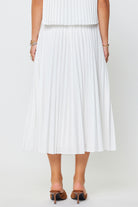 White pleated skirt worn by a person on a white background