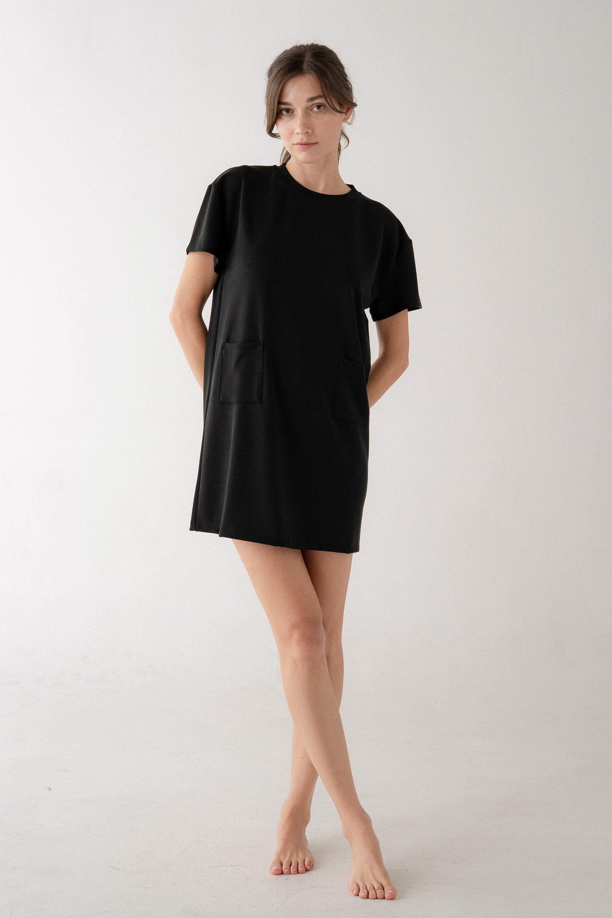 Woman wearing a black t-shirt dress on a white background