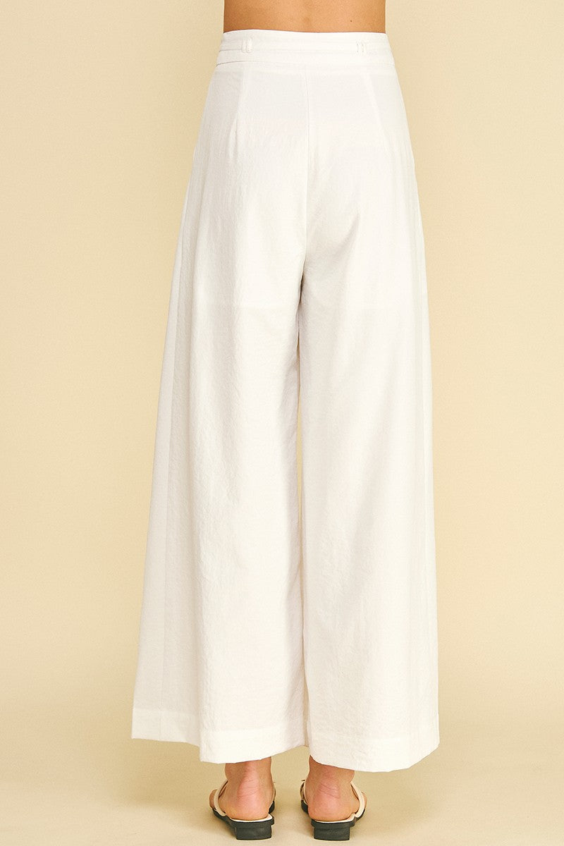 White wide-leg pants on a beige background