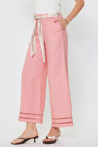 Pink pants with a decorative belt on a white background