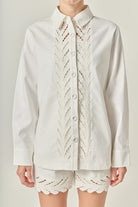 White lace-trimmed shirt and shorts set on a neutral background