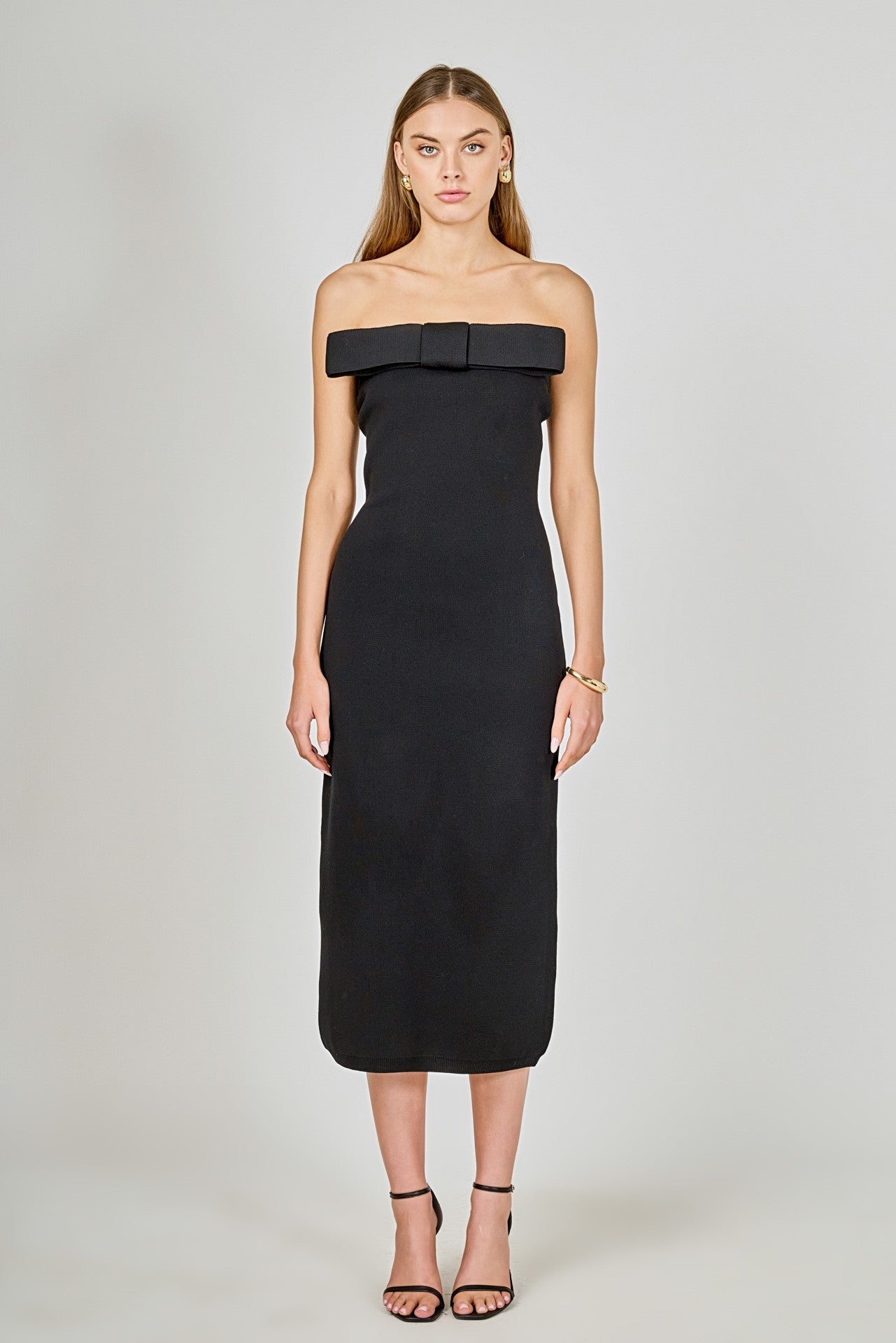 Black strapless dress with a bow detail on a white background