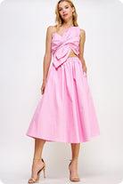 Woman wearing a pink dress with a cut-out design on a white background