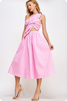 Woman wearing a pink dress with a cutout design on a white background