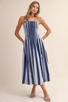 Woman wearing a blue and white striped dress on a beige background