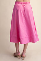 Pink skirt worn by a person on a beige background