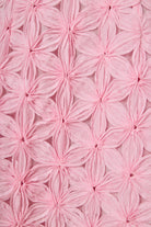 Close-up of pink textured fabric with floral patterns