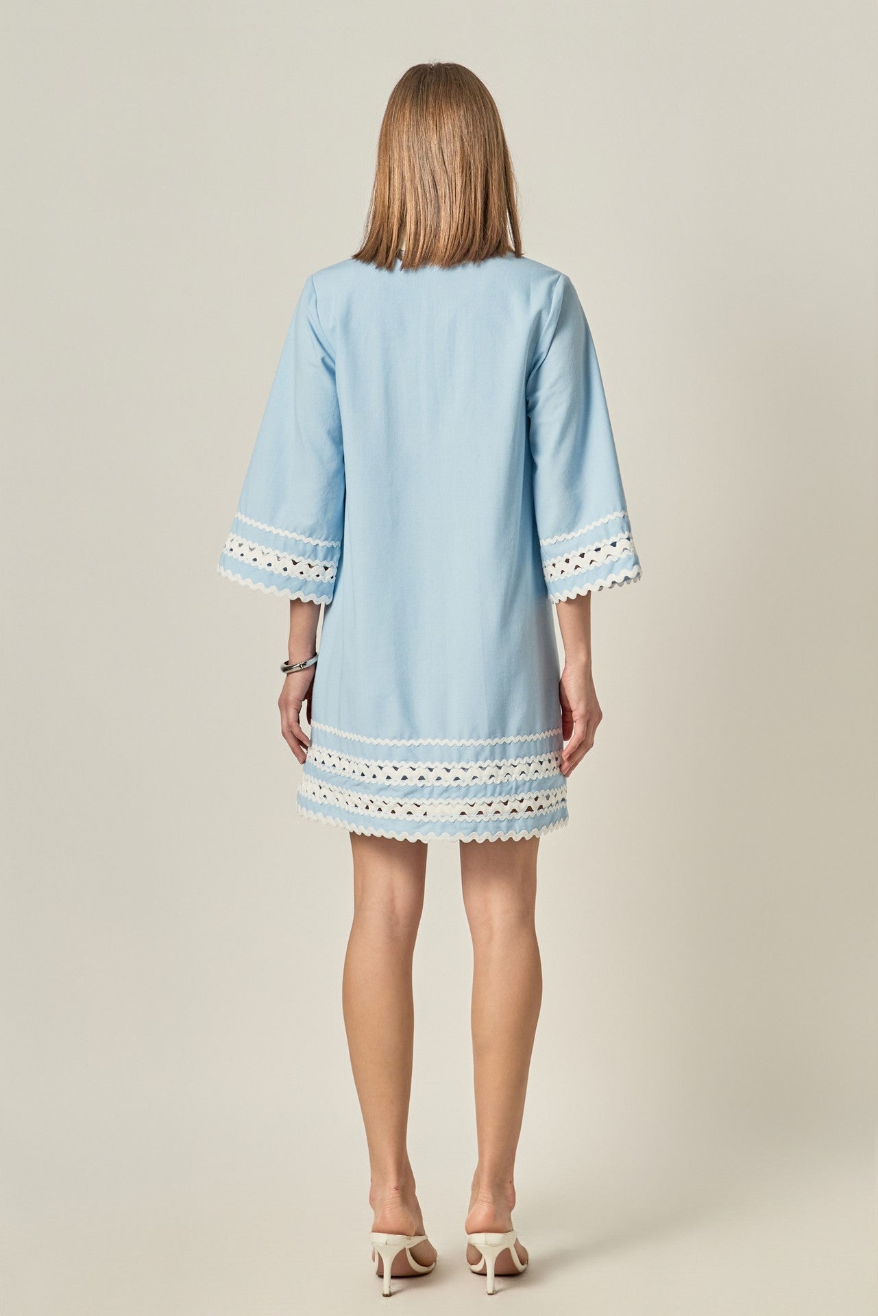 Light blue dress with lace details on a plain background