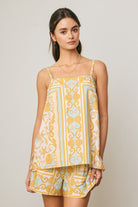 Woman wearing a yellow and blue patterned dress against a plain background