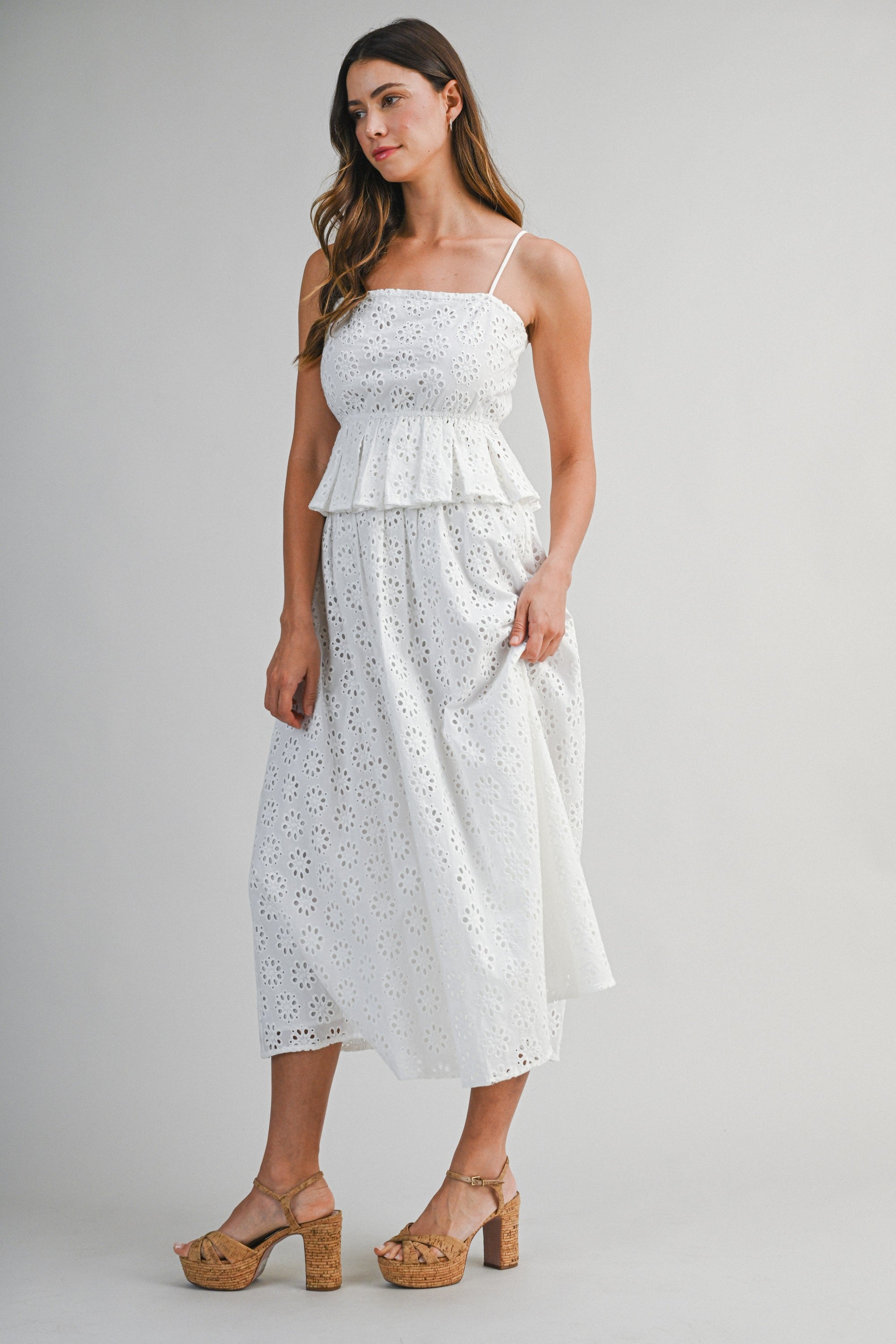 Woman wearing a white lace dress on a gray background