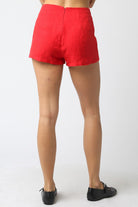 Red shorts worn by a person on a white background