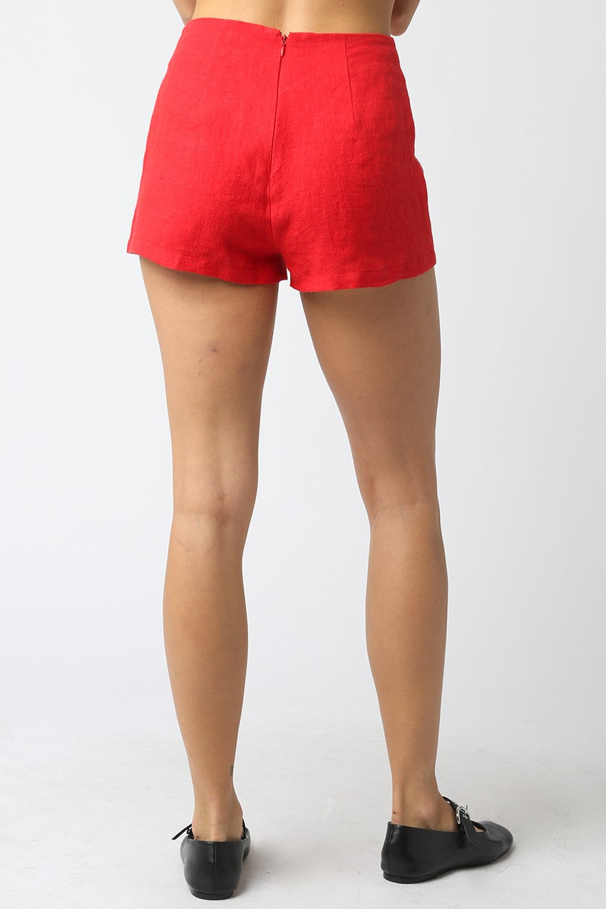 Red shorts worn by a person on a white background