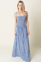 Woman wearing a blue and white striped dress on a plain background