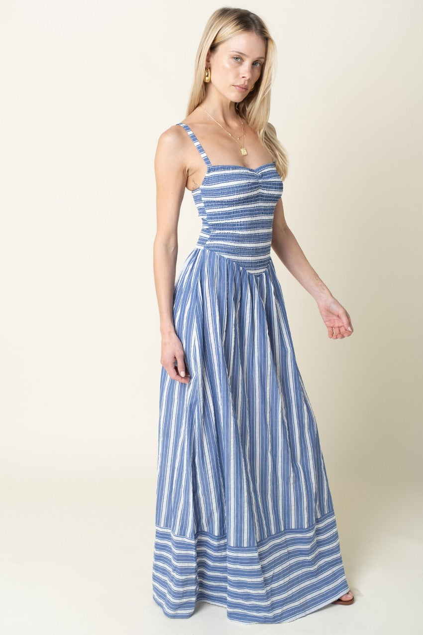 Woman wearing a blue and white striped dress on a plain background