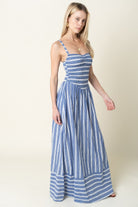 Woman wearing a blue and white striped dress on a plain background