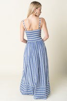 Woman wearing a blue and white striped dress on a plain background