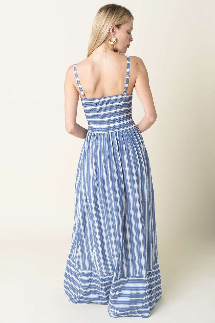 Woman wearing a blue and white striped dress on a plain background