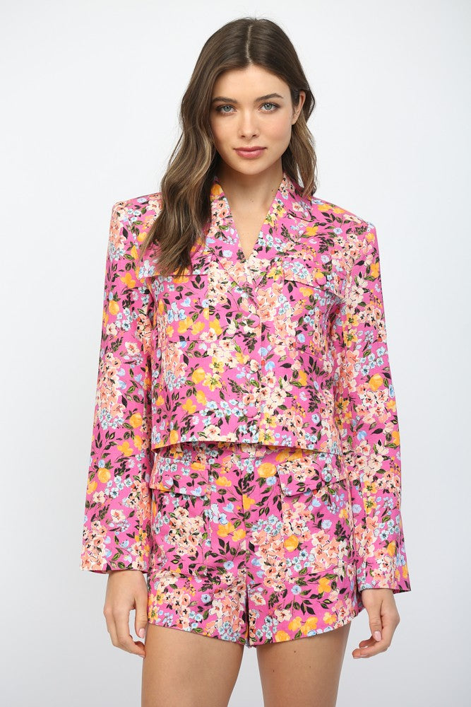 Woman wearing a pink floral two-piece set on a white background
