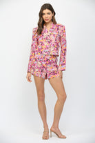 Woman wearing a pink floral outfit on a white background