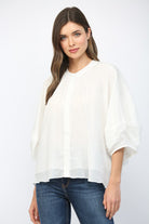 Woman wearing a white blouse and blue jeans on a white background