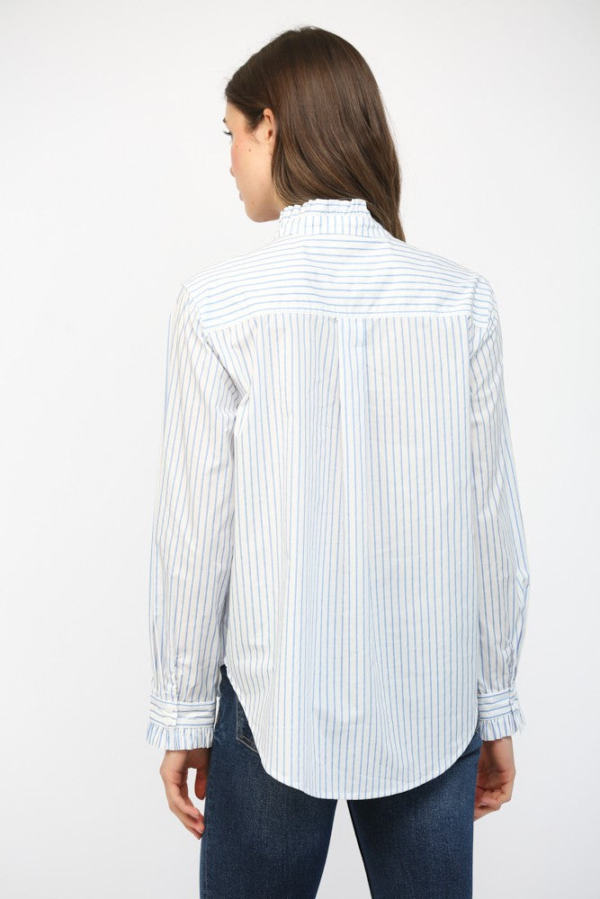 Woman wearing a white shirt with blue stripes and dark jeans on a white background